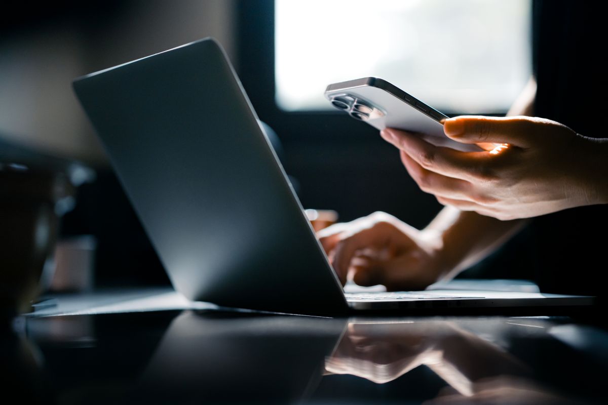 Laptop and phone with hands