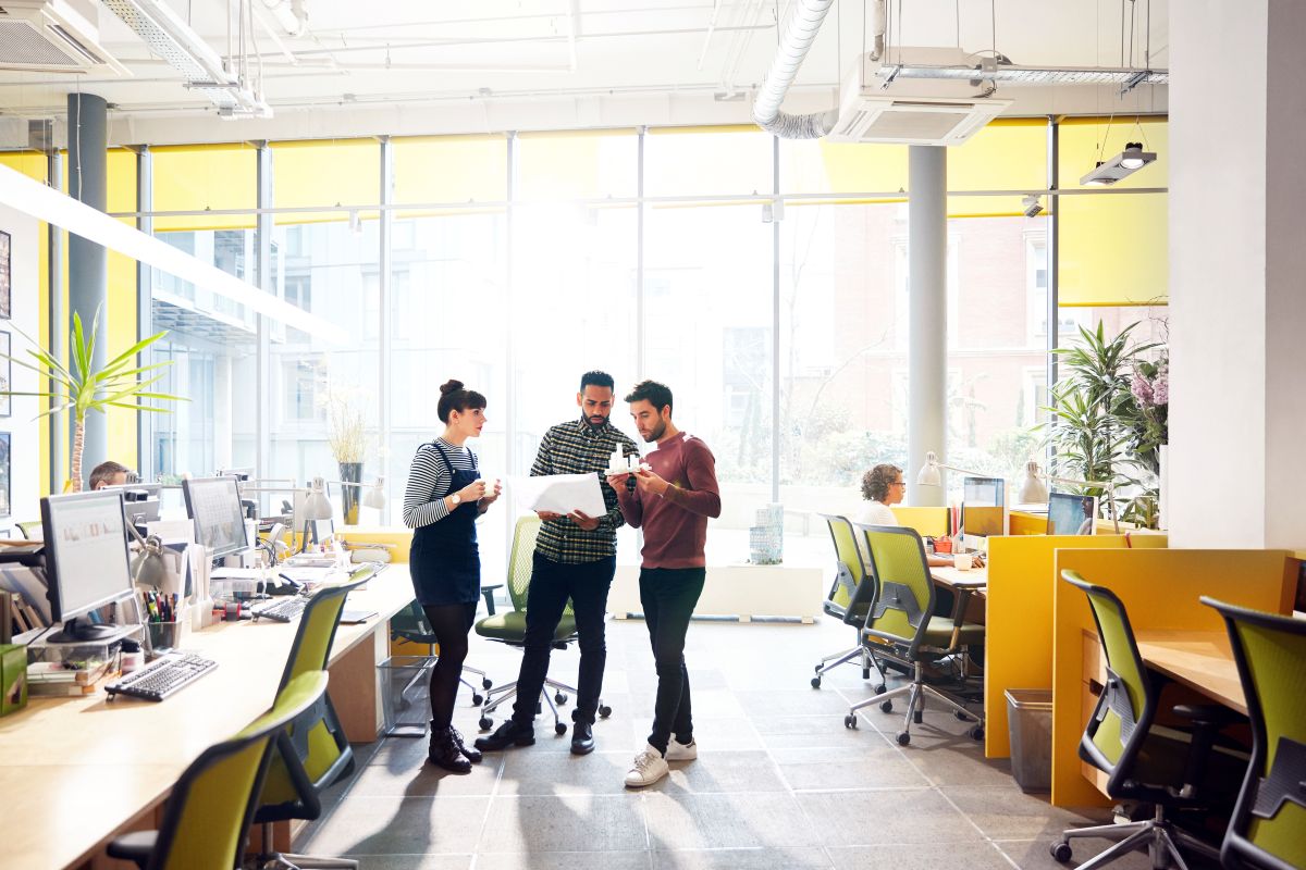Three people standing and working together
